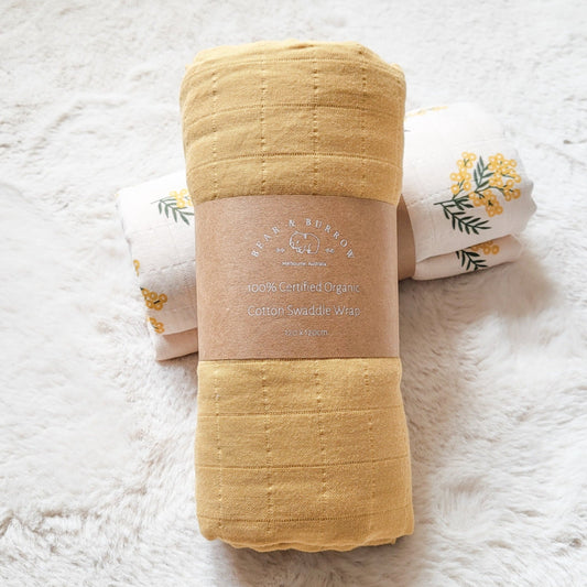Nectar yellow swaddle blanket rolled up w brown paper label